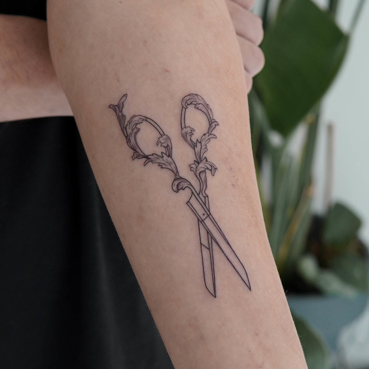 Watercolor hairdressing scissors tattoo on the forearm