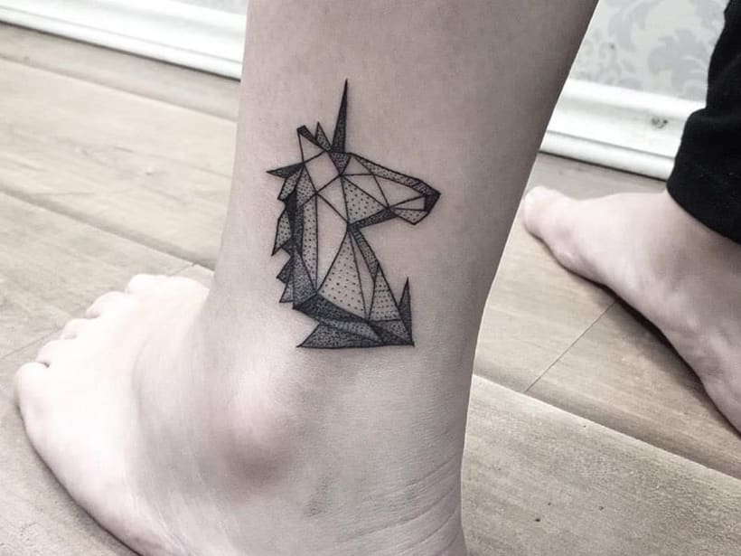 Origami unicorn tattoo on the left leg.