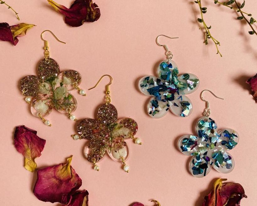 Resin floral shaped earrings with: (L) Rose gold glitter, dried flowers and freshwater pearls. (R) Crushed abalone shell.