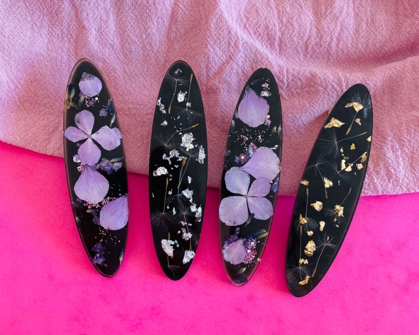 Hair clips with various additions to resin including: Dried hydrangea, dandelion seeds, gold and silver leaf.