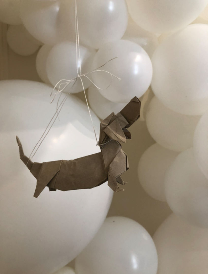 Perros de origami que cuelgan de la instalación de globos.