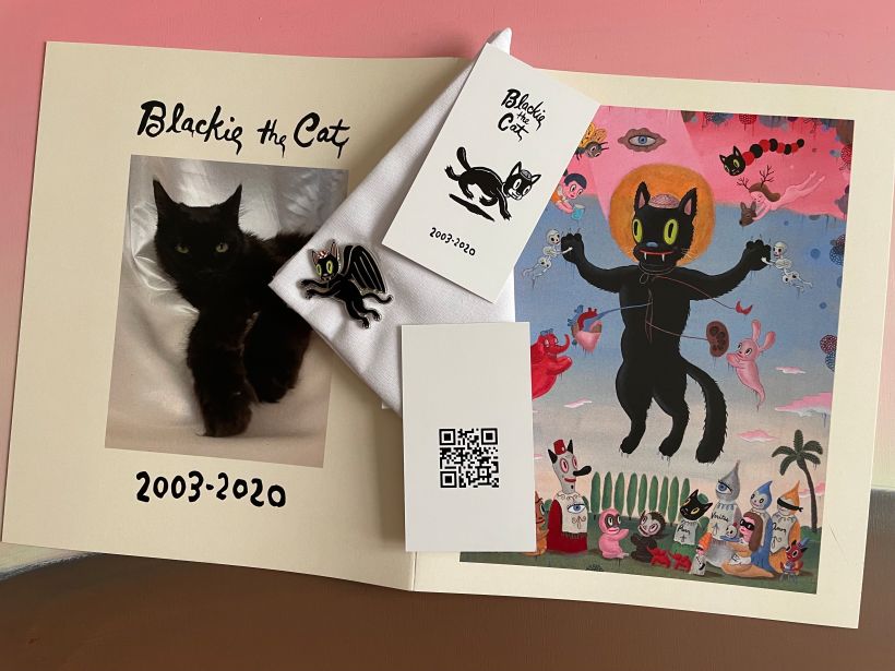 Memorial booklet, enamel pin, handkerchief, and card with QR code (no longer valid) to listen to Blackie's purr. 