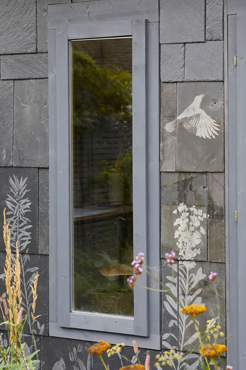Salvaged and engraved slate adorning the exterior of a garden studio. Photo by Carmel King