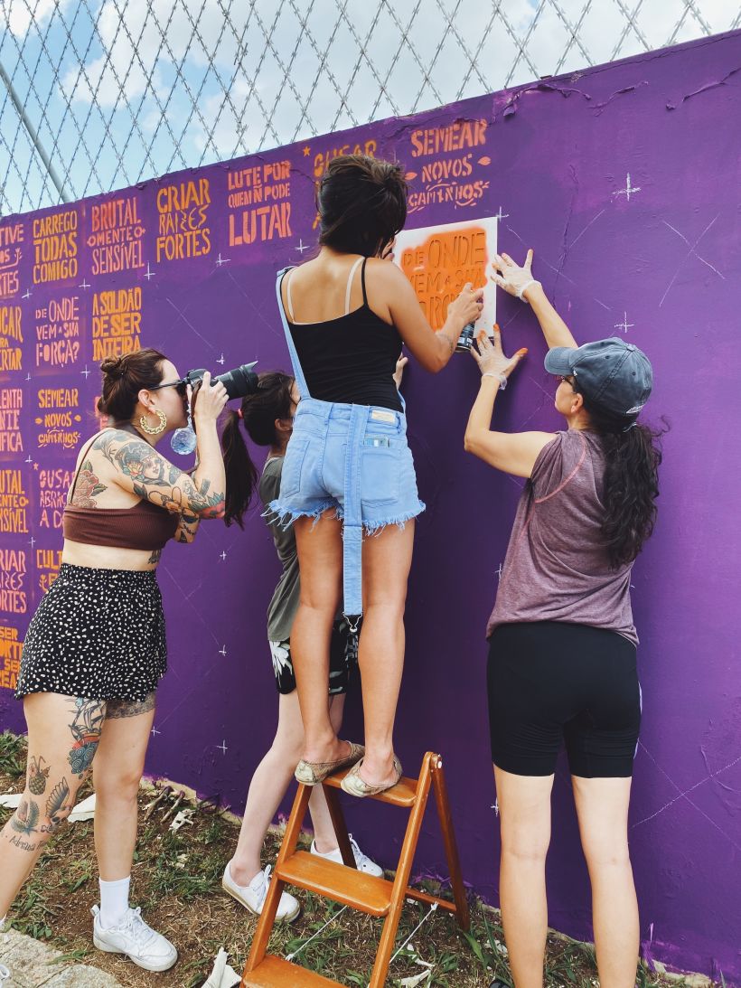 Oficina gratuita para mulheres com recortes em stencil e mural na rua, organizada por Cristina