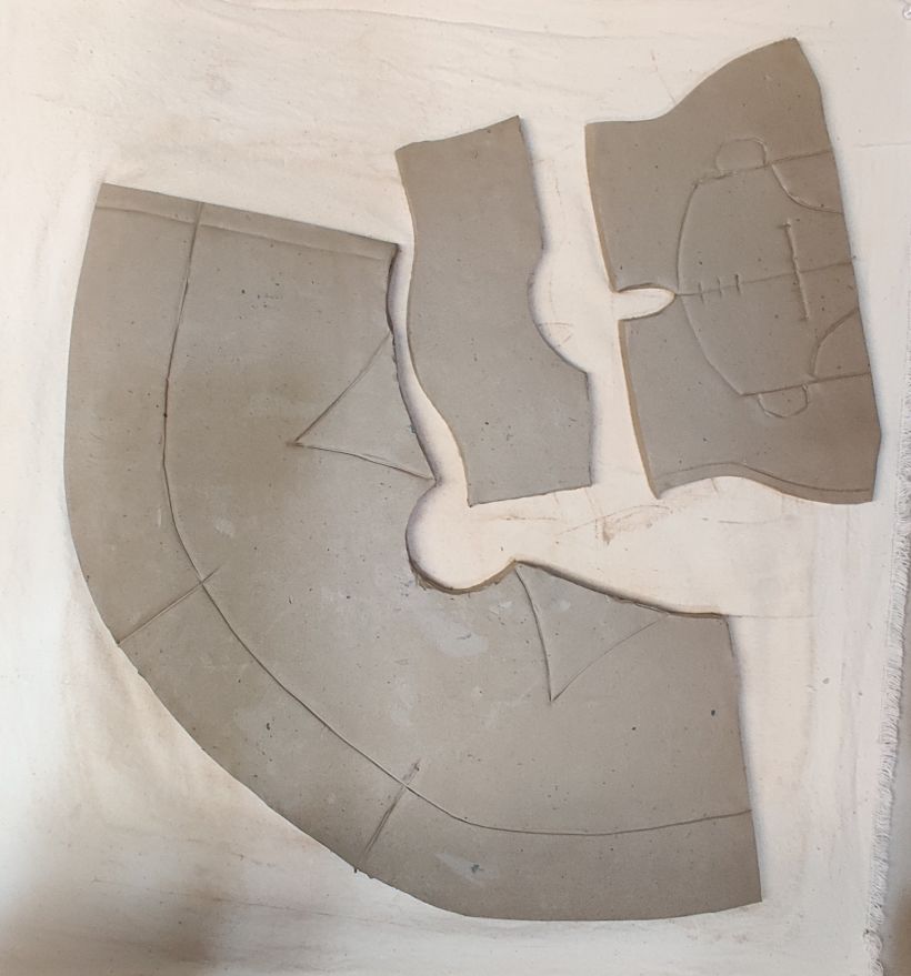 Clay slabs cut out and scored from patterns.