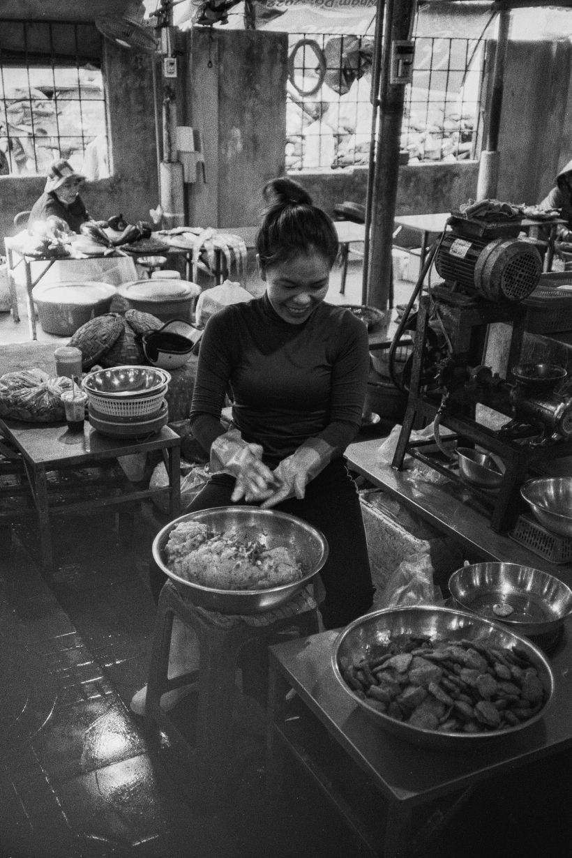 A woman makes fresh fish cakes at Man Thai market.
