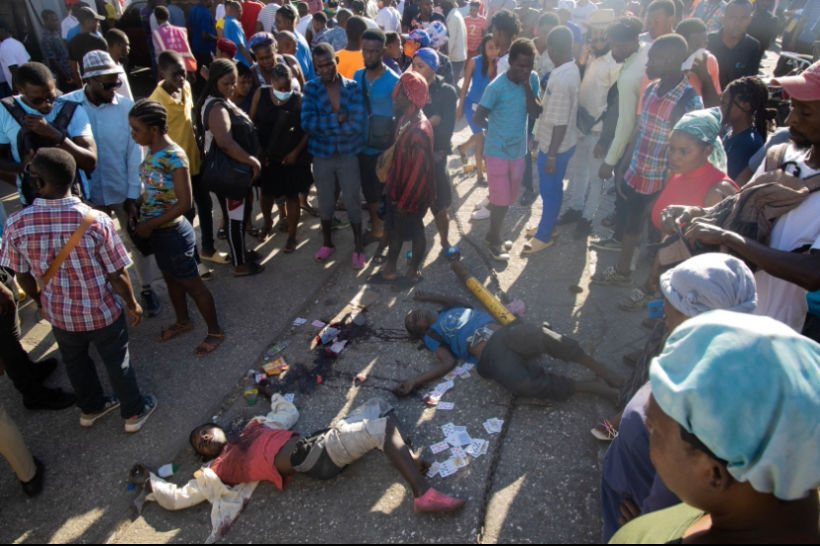 people observing corpses of men being shot in Port-au-Prince, Haiti, March 01, 2024. (Photo/Pierre Marckinson)