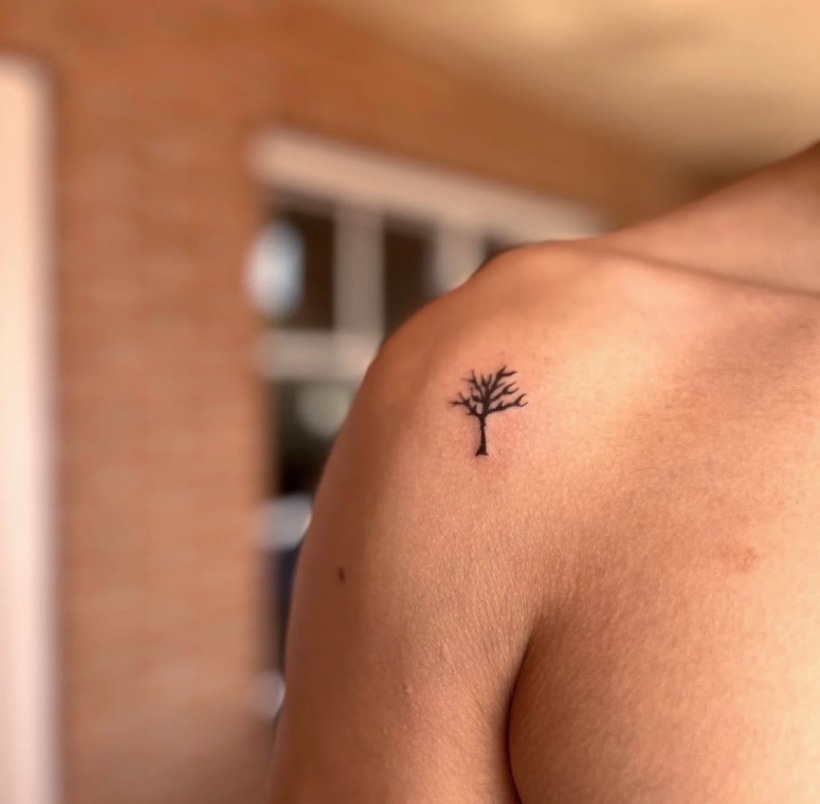 Fine line pine tree tattoo located on the upper arm