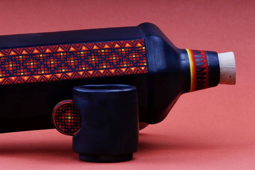 Botella y vaso para mezcal hechos en barro negro, intervenidos por artesanos oaxaqueños.