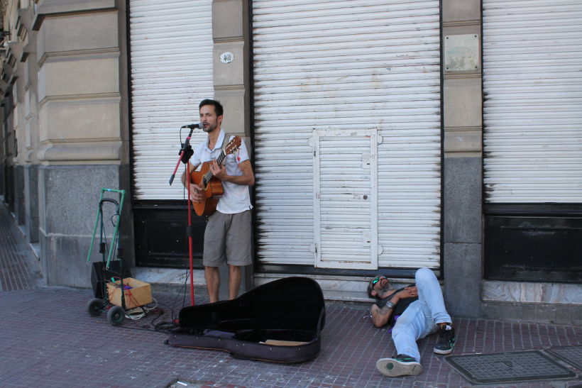 Artista callejero y hombre durmiendo en la calle en San Telmo, BsAs.